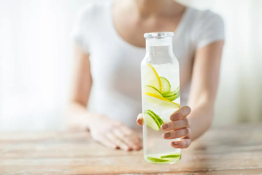 woman white top holding detox water woman white top holding detox water