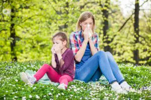 mother daughter outside sneezing