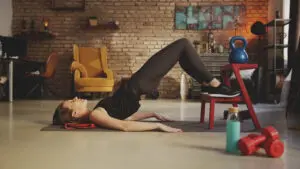 Fitness training at home. Young woman doing abdomen workout, exercising in living room. Stay at home and stay fit and healthy.