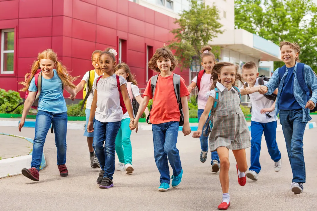 A group of children walking down the sidewalk