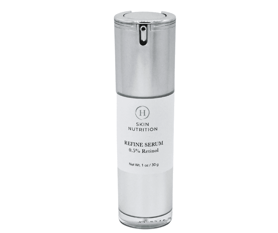 A bottle of facial serum with silver cap.