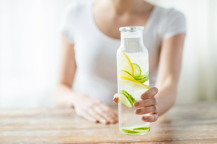 woman white top holding detox water