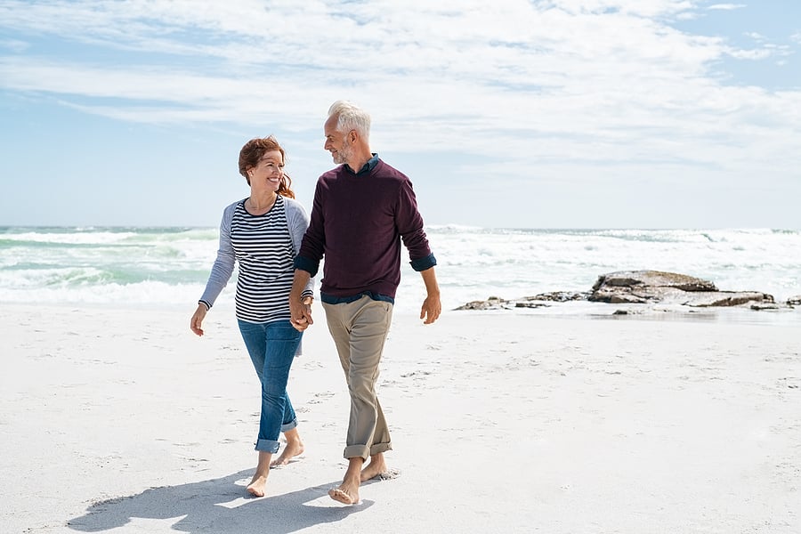 mature couple walking on beach