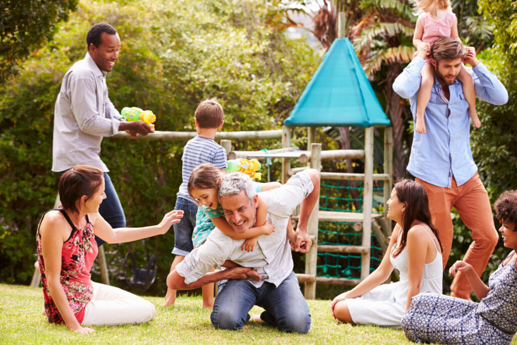 Adults and kids having fun playing in the backyard.