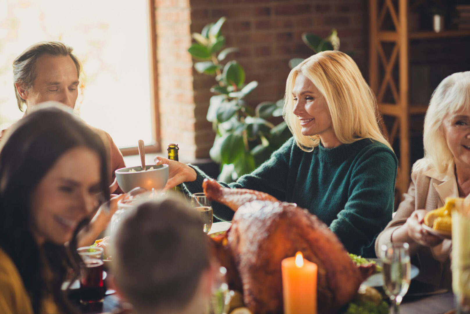 Photo of full family gathering thanksgiving feast served dinner chatting starting meal house evening living room indoors keeping in mind healthy holiday eating tips.