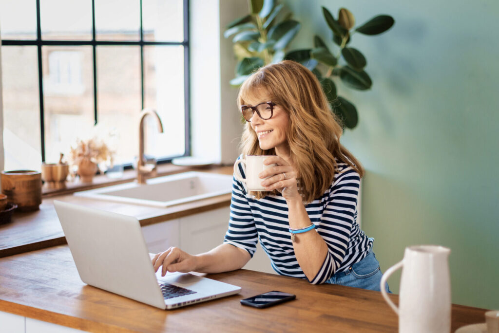 Woman on her computer in the kitchen checking her metabolomix testing results.