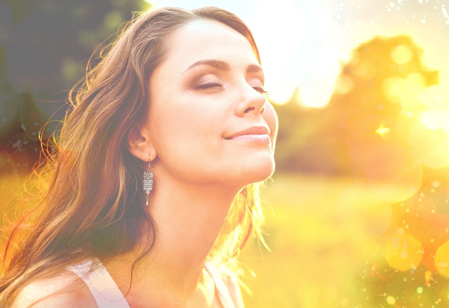 Woman in a field with sun shining on her face, sunlight and vitamin d