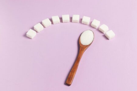 Sugar cubes with wooden spoon pointing to high end of arch for blood sugar affecting emotions and energy.