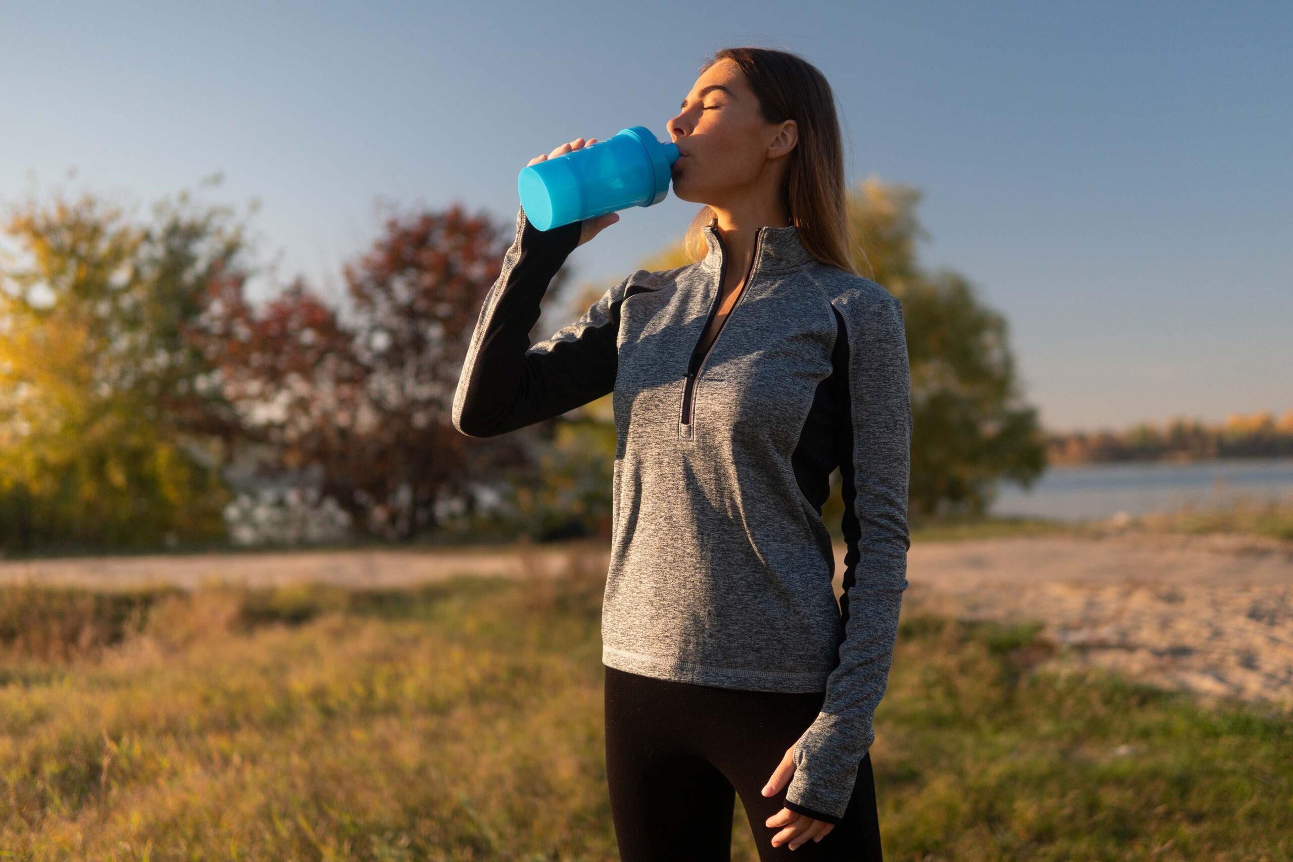 Woman holding a protein shake, one of the key supplements to take on GLP-1 therapy.