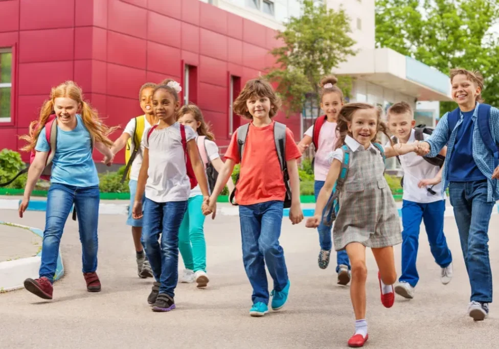 A group of children walking down the sidewalk