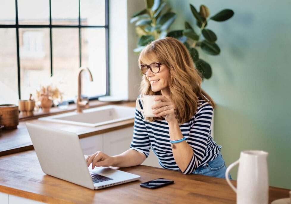 Woman on her computer in the kitchen checking her metabolomix testing results.