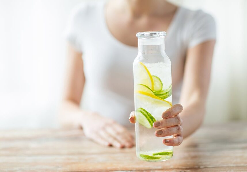 woman white top holding detox water woman white top holding detox water